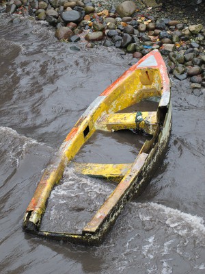 Dead boat lying on the shore