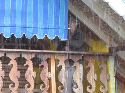 Winn rolls down the awning to protect from driving rain
